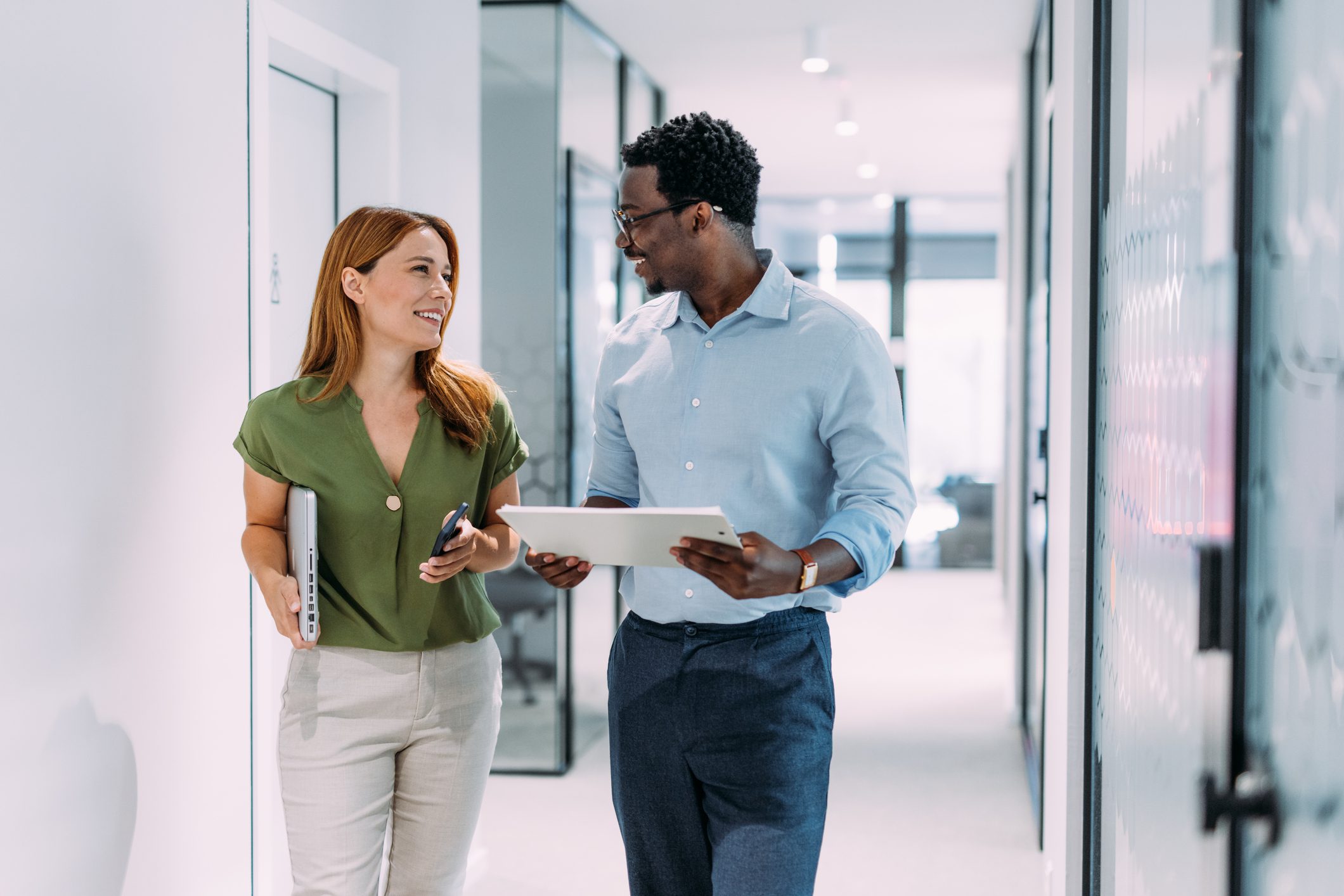 Colleagues discussing in office hallway